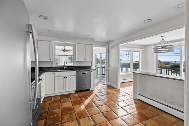 kitchen featuring a baseboard radiator, dark countertops, a sink, and appliances with stainless steel finishes