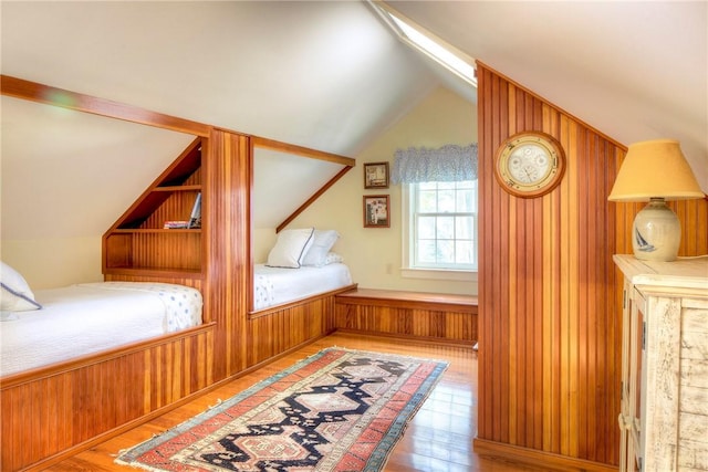 unfurnished bedroom with hardwood / wood-style flooring and vaulted ceiling