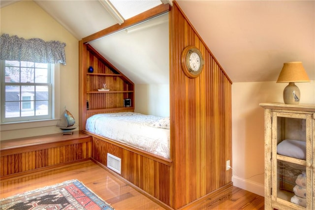 unfurnished bedroom featuring lofted ceiling and light hardwood / wood-style flooring