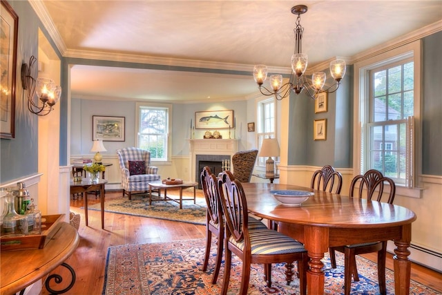 dining space featuring hardwood / wood-style floors, a notable chandelier, and ornamental molding