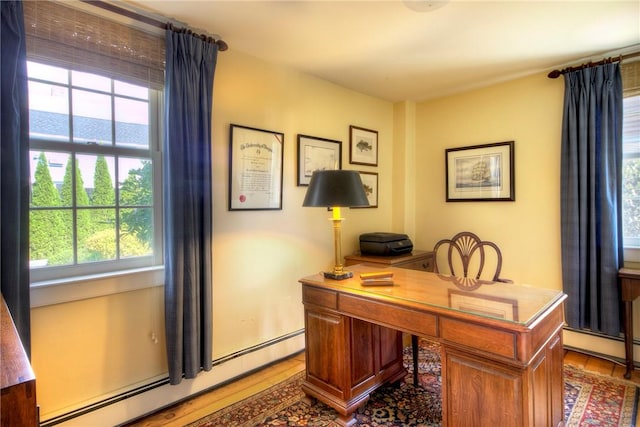 office area with hardwood / wood-style flooring and a baseboard heating unit