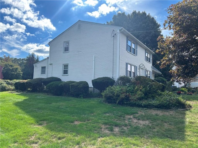 view of property exterior featuring a lawn