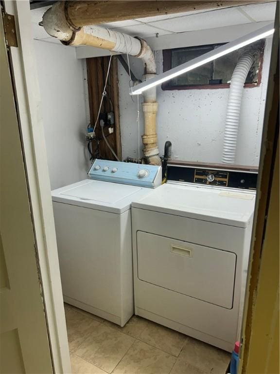 washroom with washing machine and dryer and light tile patterned flooring