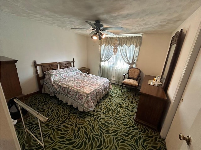 bedroom with ceiling fan, carpet flooring, and a textured ceiling