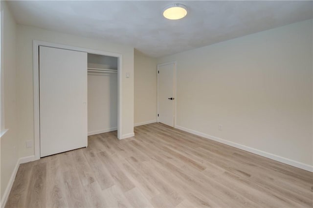 unfurnished bedroom with light hardwood / wood-style floors and a closet