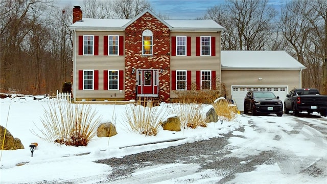 colonial house with a chimney and an attached garage