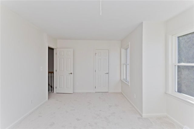 empty room with baseboards, a wealth of natural light, and carpet flooring