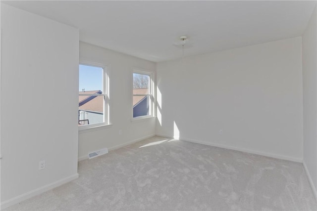 carpeted spare room with baseboards and visible vents