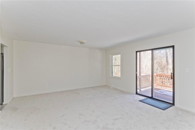 unfurnished room featuring baseboards and light colored carpet