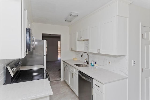 kitchen with tasteful backsplash, light countertops, appliances with stainless steel finishes, white cabinetry, and a sink