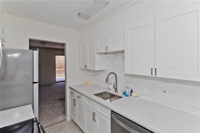 kitchen featuring light countertops, backsplash, appliances with stainless steel finishes, white cabinetry, and a sink