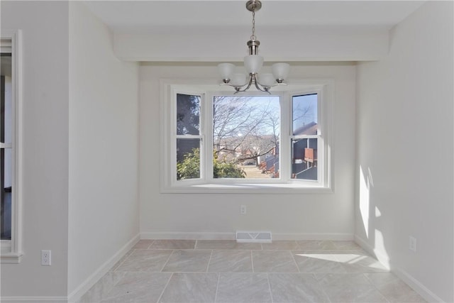 unfurnished dining area featuring baseboards, visible vents, and a notable chandelier