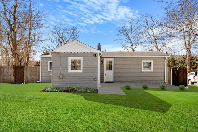 back of house with a patio and a lawn