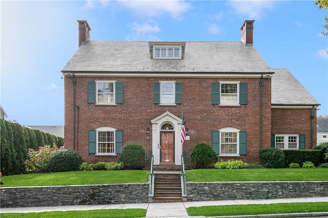 colonial home featuring a front lawn