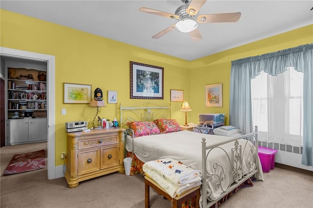 bedroom with a ceiling fan, light colored carpet, and baseboards