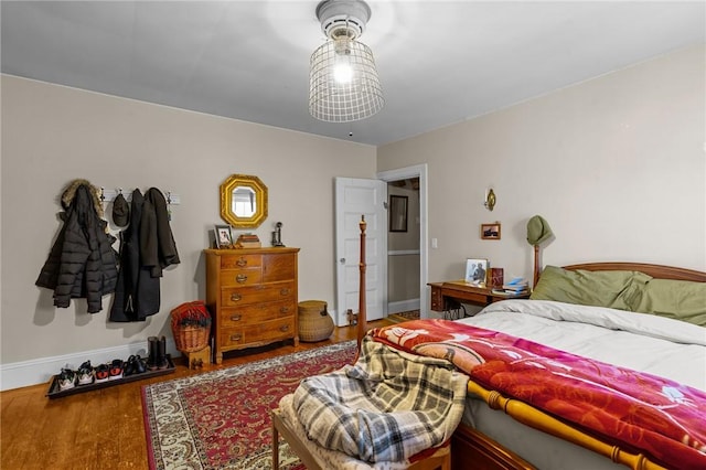 bedroom with wood finished floors and baseboards