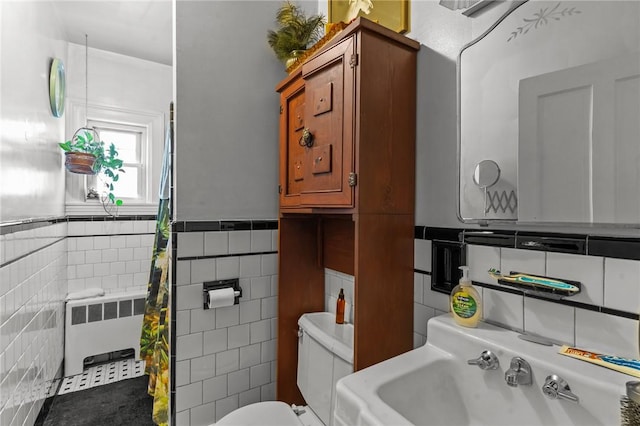 full bath featuring toilet, a wainscoted wall, a sink, tile walls, and radiator heating unit