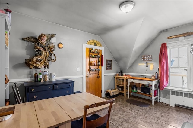 dining room with tile patterned flooring, radiator, and vaulted ceiling