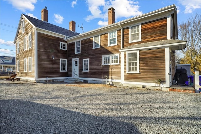 rear view of property featuring entry steps and a chimney