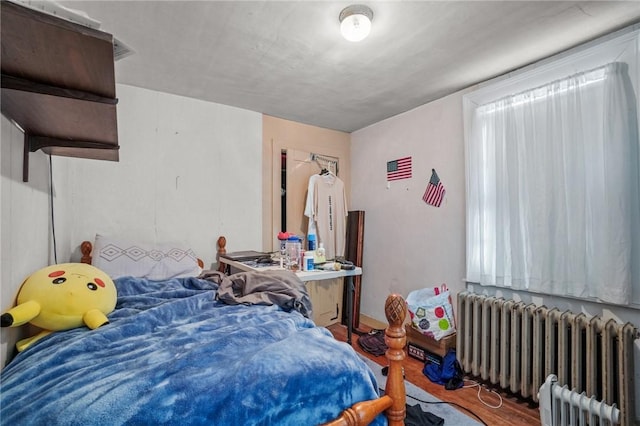 bedroom with wood finished floors and radiator