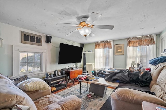 living room with a ceiling fan, radiator heating unit, and wood finished floors