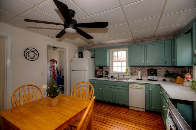 kitchen with a paneled ceiling, sink, green cabinets, and white appliances