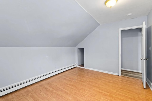 bonus room with lofted ceiling, a baseboard radiator, and light hardwood / wood-style floors