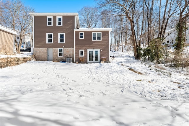 snow covered rear of property with french doors