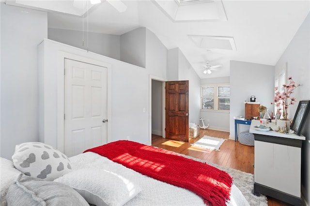 bedroom with lofted ceiling, attic access, a ceiling fan, wood finished floors, and baseboards