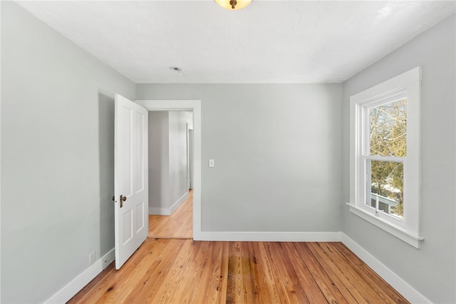 unfurnished room with light wood finished floors and baseboards