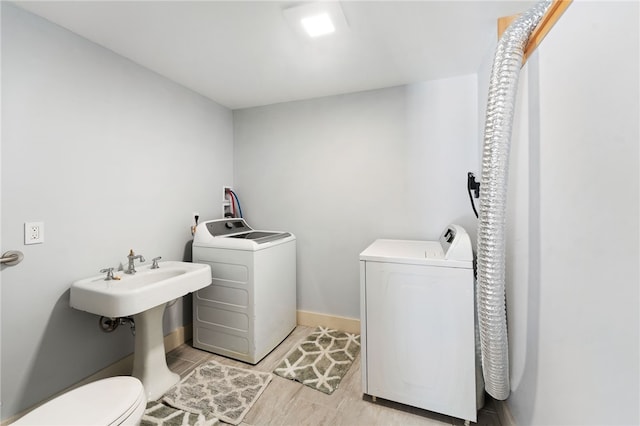 interior space featuring toilet, baseboards, and washer and clothes dryer