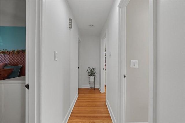 hallway featuring baseboards and light wood finished floors