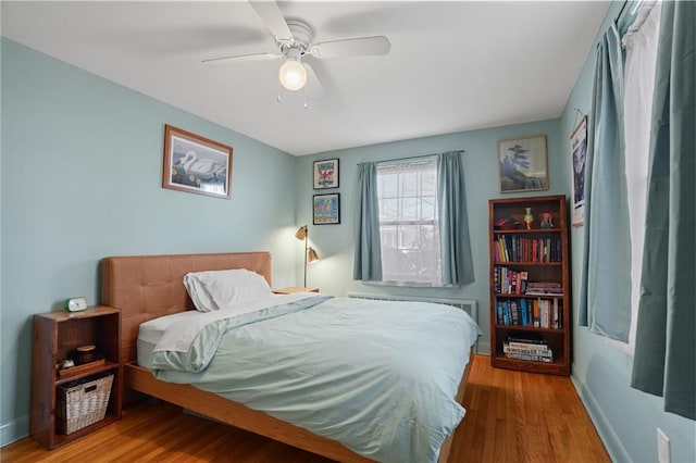 bedroom with wood finished floors, baseboards, and ceiling fan