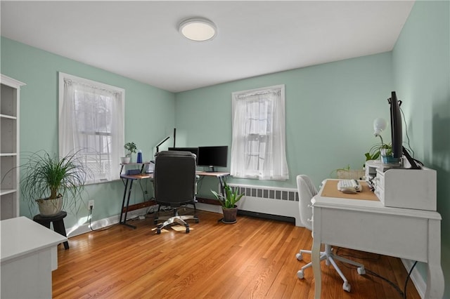 office space featuring radiator, wood finished floors, and baseboards