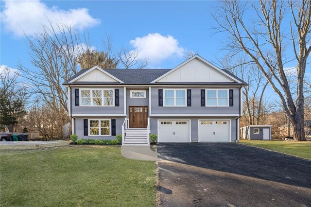 bi-level home with a garage, a front yard, and a shed