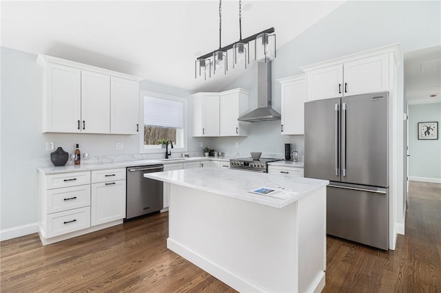 kitchen with a kitchen island, white cabinetry, sink, stainless steel appliances, and wall chimney exhaust hood