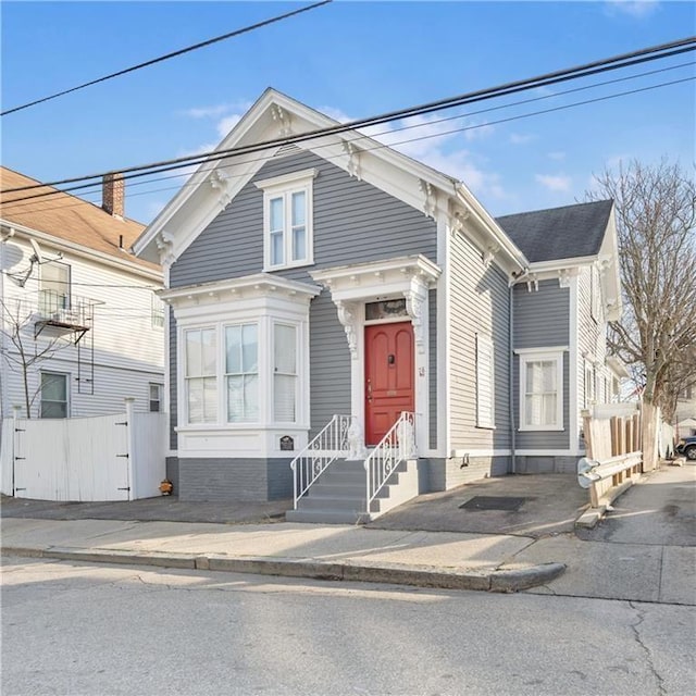 view of front facade with entry steps and fence