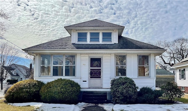 bungalow-style house with a shingled roof and entry steps