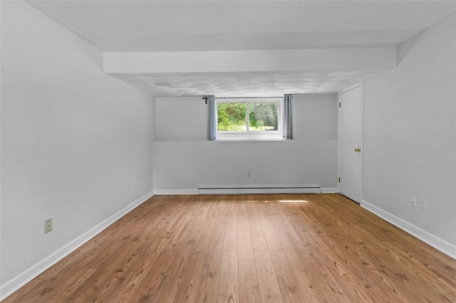 unfurnished room with light hardwood / wood-style flooring and baseboard heating