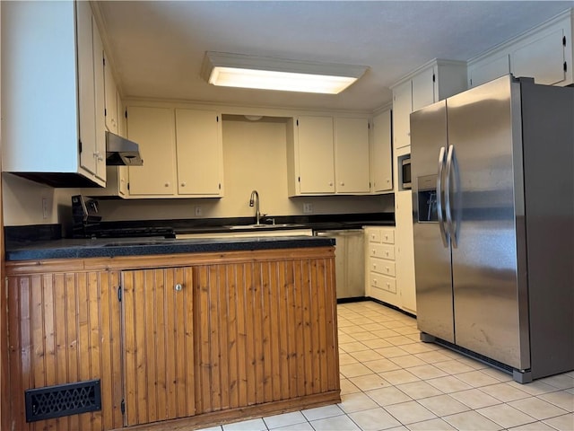 kitchen with sink, white cabinets, light tile patterned floors, kitchen peninsula, and stainless steel appliances