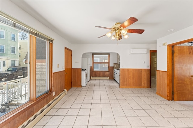 interior space with an AC wall unit, a wealth of natural light, wood walls, and a baseboard radiator