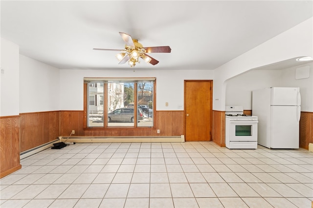 interior space with ceiling fan and wood walls