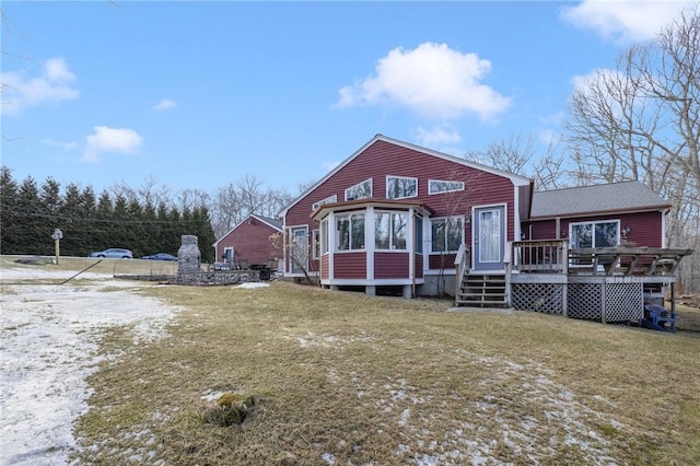 rear view of house with a deck and a yard