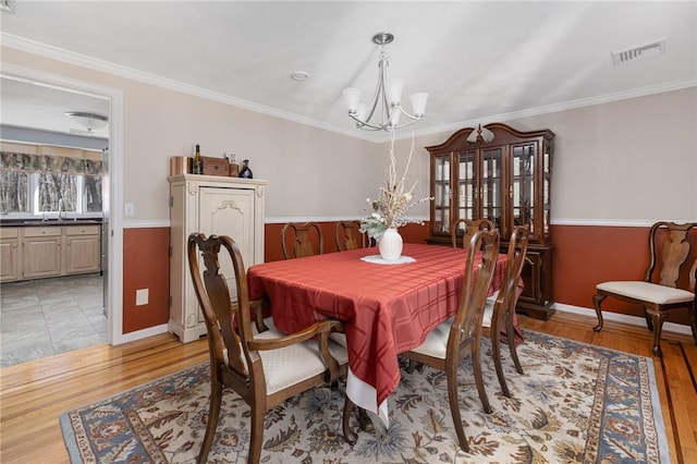 dining space with visible vents, crown molding, and an inviting chandelier