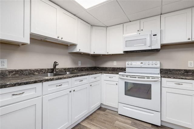 kitchen featuring light wood-type flooring, white appliances, white cabinetry, and a sink