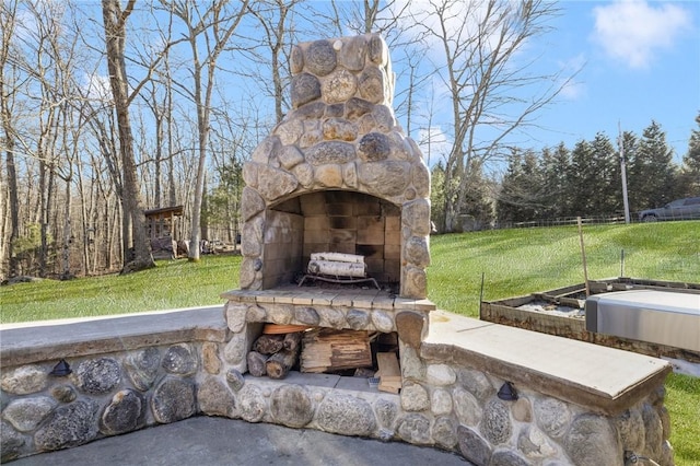 view of patio with an outdoor stone fireplace and fence