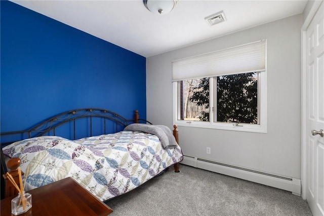 bedroom with a baseboard heating unit, carpet flooring, and visible vents