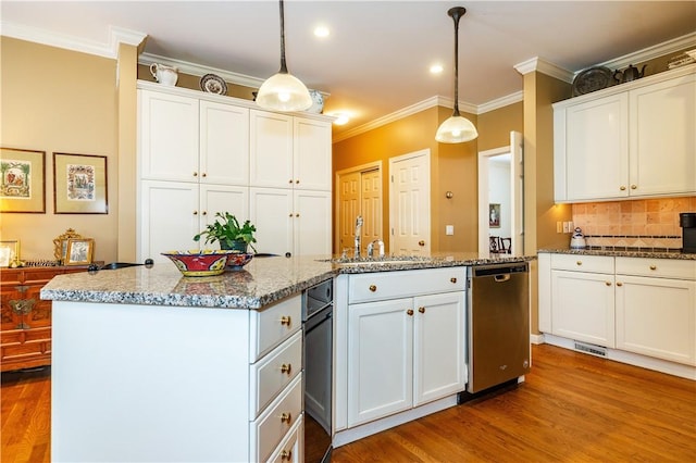 kitchen featuring white cabinets, dishwasher, and decorative light fixtures