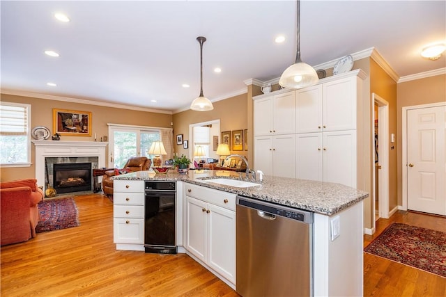 kitchen featuring a center island with sink, sink, pendant lighting, dishwasher, and white cabinets