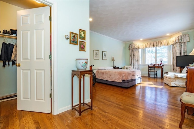 bedroom featuring a closet, hardwood / wood-style flooring, and crown molding